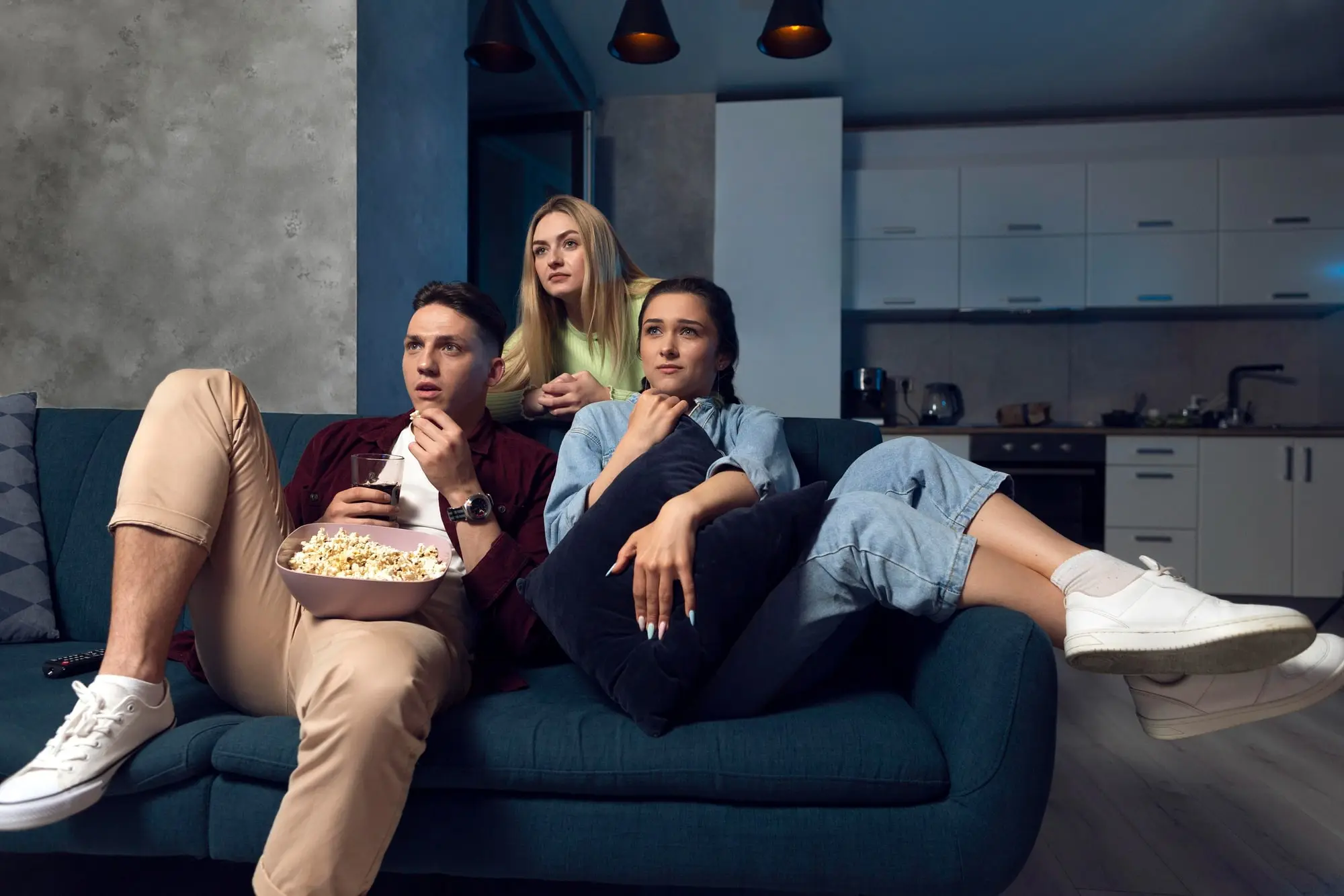 Friends watching IPTV UK streaming service together on the sofa in a British living room